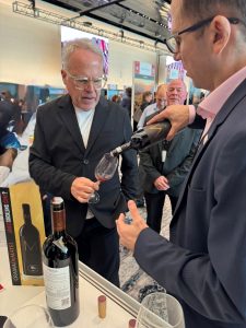 James Suckling degust&acirc;nd un vin Crama DeMatei la un eveniment internațional.