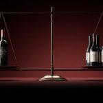 Greutatea sticlei de vin ilustrată prin balanță – o sticlă grea vs. mai multe sticle ușoare