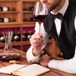 Somelier analizând un pahar de vin roșu – cursuri despre vin