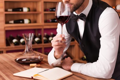 Somelier analizând un pahar de vin roșu – cursuri despre vin