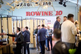 Participanți la festivalul RO-Wine 10 ani la Fratelli Studios București, printre standuri de vinuri premium