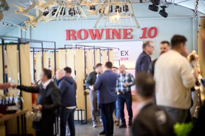 Participanți la festivalul RO-Wine 10 ani la Fratelli Studios București, printre standuri de vinuri premium