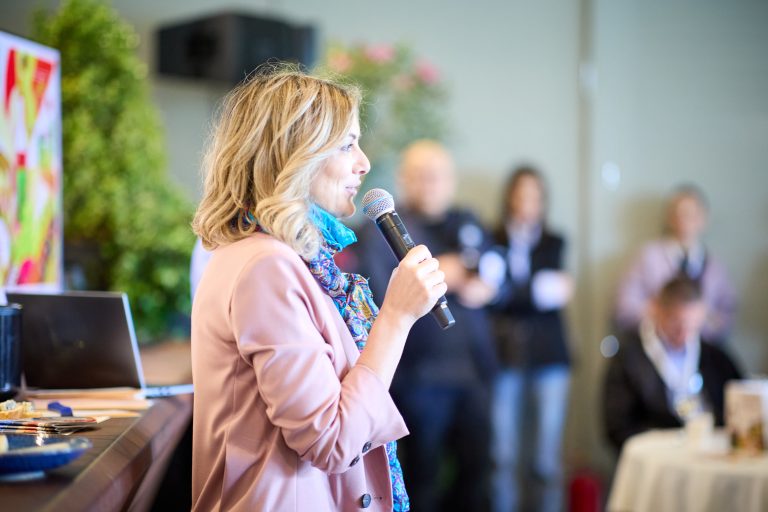 O vorbitoare țin&acirc;nd un discurs &icirc;n cadrul festivalului RO-Wine 2025, despre cultura vinului și inovația din industria oenologică.