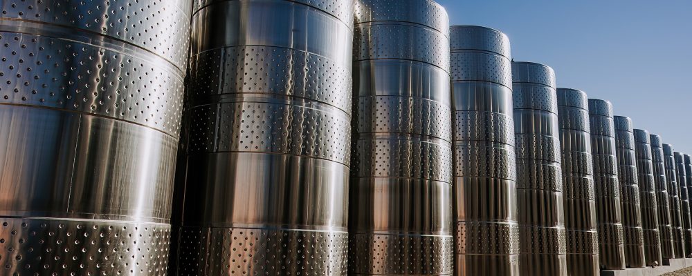 Steel modern cisterns for wine production on plant territory. Large tanks, barrels on winery factory. High quality photo [ENVATO x WoR]